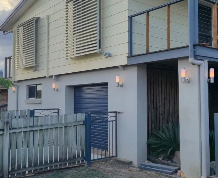 After: the same home with new outdoor wall lights beside the garage and doorway