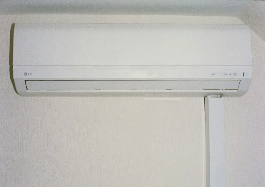Split system air conditioner mounted high on a white wall