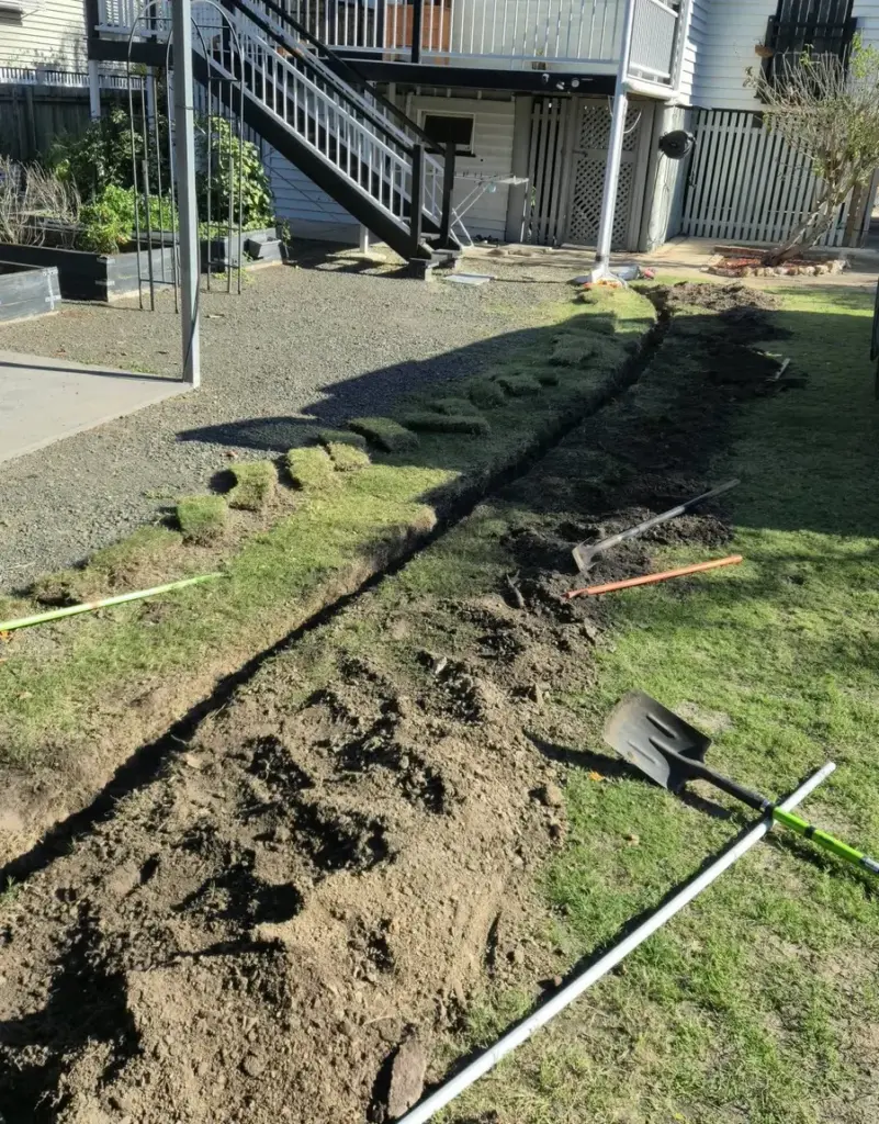 Underground cable trench and conduit running across the yard of a Queenslander home