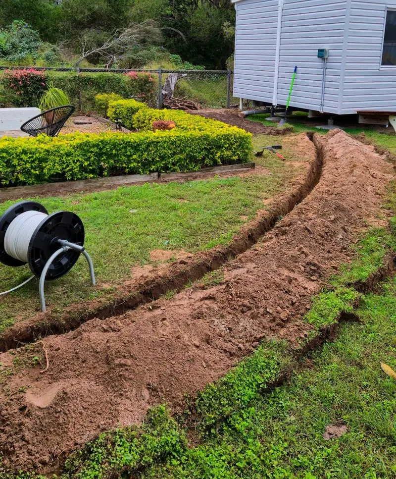 Trench dug through a garden to run underground power to a new modular home